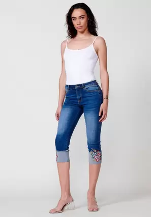 Oferta de Pantalón pirata acabado en vuelta con detalle bordado floral color Azul para Mujer por 49,99€ en Koröshi