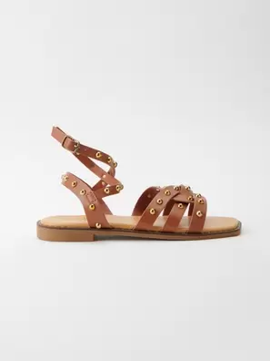 Oferta de Sandalias planas tiras efecto piel con tachuelas metalícas y Cierre con hebillas en el tobillo color Marrón para Mujer por 49,99€ en Koröshi