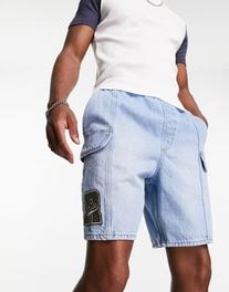 Oferta de Pantalones cortos vaqueros cargo sin cierres de largo estándar con lavado azul medio y detalle de parche de ASOS DESIGN por 28,49€ en Asos
