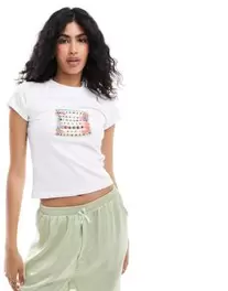 Oferta de Camiseta blanca con diseño encogido y estampado de pulseras de la amistad de ASOS DESIGN por 8€ en Asos